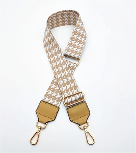 Detail of adjustable wide houndstooth bag strap with khaki PU leather and gold hardware