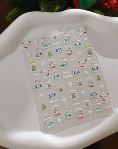 Detail of 3D embossed Christmas nail stickers with snowman and elk motifs on a tray