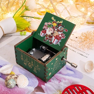 Close-up of wooden hand-crank music box showing internal clockwork and Christmas illustrations