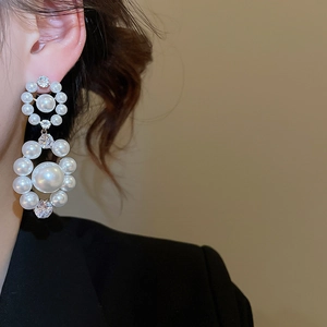 Gros plan de boucles d'oreilles perles et zircons sur un mannequin style rétro luxe