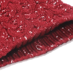 Detail showing the ribbed edge and red chunky cable knit texture of the beanie