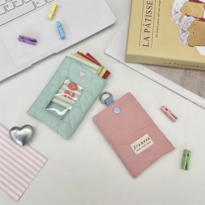 Detailed view of quilted heart card holders in mint and pink fabric with metal clip