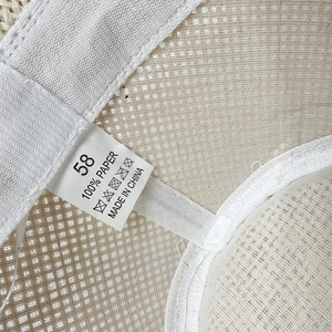 Macro shot of the straw sun hat interior showing the woven texture and size 58 paper label