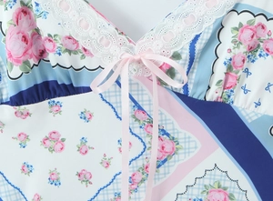Détail d'une robe fleurie rose avec motif à carreaux bleus et bordure en dentelle