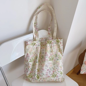 Détail du sac cabas en coton fleuri avec imprimés floraux sur une chaise pliante blanche