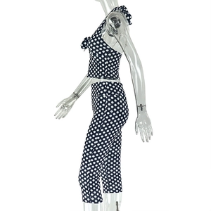 Side view of navy blue two-piece tracksuit with white polka dots on a mannequin