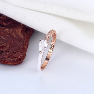 Macro detail of pear cut zircon and white enamel on a rose gold S925 silver ring