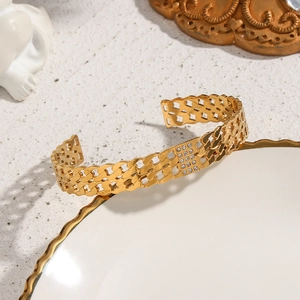 Detailed view of golden double-layer curb chain bracelet with pavé-set cubic zirconia