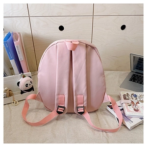Pink student backpack with comfortable padded shoulder straps on a desk setup