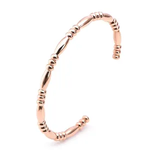 Detailed view of rose gold C-shaped open bangle with bead and bamboo joint design