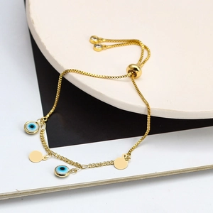 Dettaglio del bracciale occhio del male dorato con chiusura regolabile su base bianca