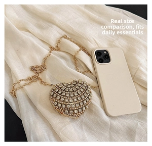 Détail du sac de soirée en forme de cœur avec strass blancs et chaîne dorée