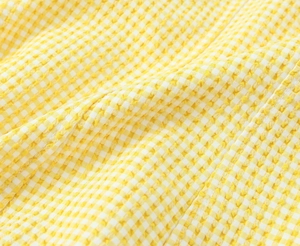 Detaillierte Makroansicht der gelb-weißen Gingham-Seersucker-Stoffstruktur