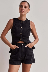 Dettaglio di un set in denim nero con top senza maniche bottoni e pantaloncini abbinati