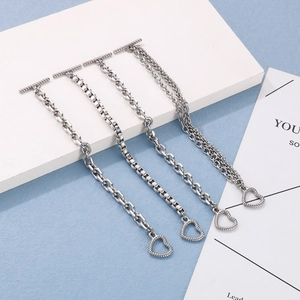 Detail of four silver chain bracelets featuring heart pendants and T-bar toggle clasps