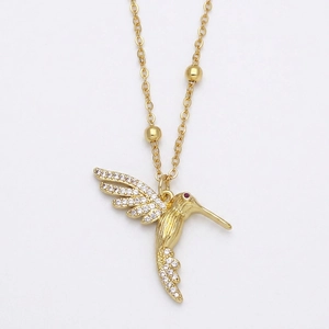 Collier colibri doré avec ailes serties de zircons et œil en gemme rouge sur chaîne