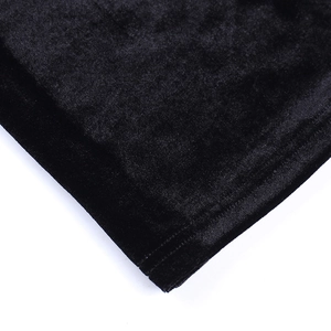 Gros plan sur la texture du velours noir et les coutures de précision sur l'ourlet