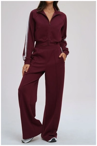 Detail of burgundy sports set featuring contrast white stripes on sleeves and tall collar