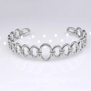 Close-up of silver chain link bracelet with polished oval rings on a reflective white surface