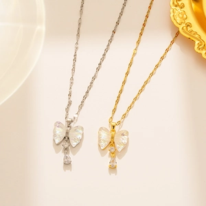 Detail of silver and gold butterfly necklaces with mother of pearl and teardrop crystals