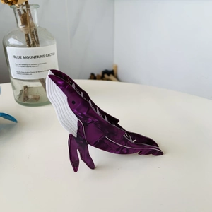 Macro view of purple marble whale hair claw clip with white striped belly design