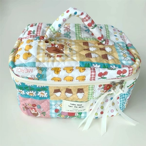Quilted cotton makeup bag with cute cartoon patches and ribbon zipper on light background