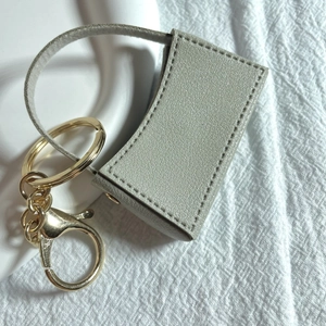 Llavero estuche para pintalabios en cuero gris claro con elegante mosquetón dorado