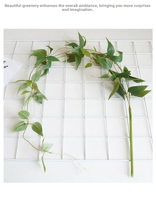 Detail of lifelike artificial clematis vine foliage on white mesh display stand