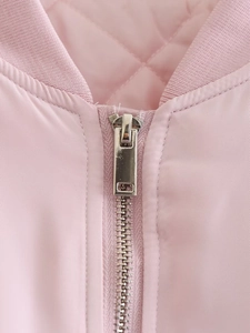 Detail of pink jacket showing metal zipper, ribbed collar, and quilted lining texture