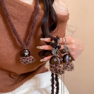 Collier vintage avec pendentif coeur en peluche léopard sur un pull marron rétro