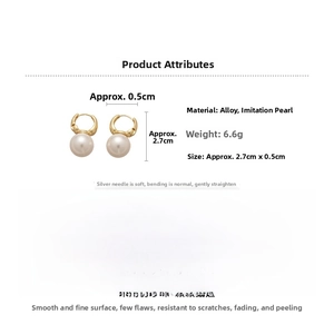 Detail view of retro gold pearl earrings with dimensions 2.7cm height and 0.5cm diameter