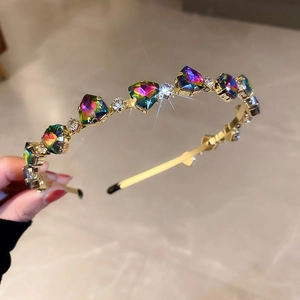 Detail of golden headband with emerald green crystals and sparkling cubic zirconia