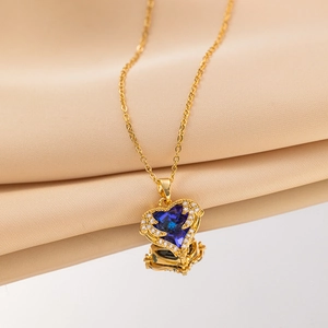 Vintage gold necklace with blue heart crystal pendant on elegant satin background