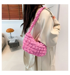 Detailed texture of pink bubble pleated cloud bag shown on model in trench coat