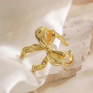 Anello regolabile a fiocco placcato oro 18K su elegante sfondo in seta bianca