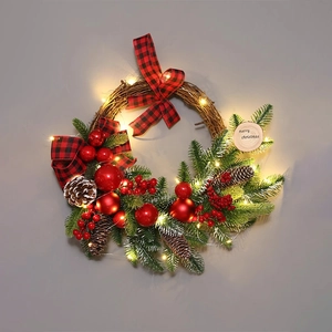 Illuminated Christmas wreath with red plaid bow, pine cones, and LED lights on a wall