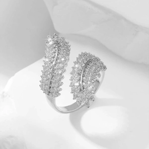 Silver adjustable feather open ring with zircon paving on white stone background