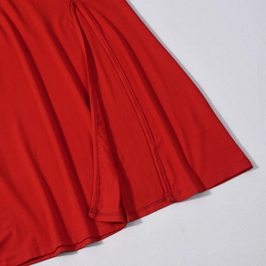 Detailed close-up of high slit seam and soft knit fabric on a red bodycon dress