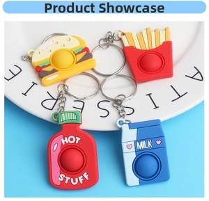 Macro view of silicone pop-it keychains shaped like burgers and fries on a white plate