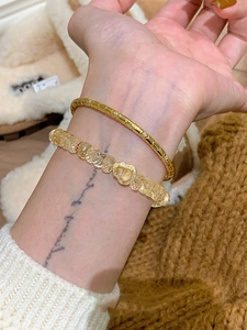 Détail du bracelet bambou doré avec zircon et gourmette perlée jaune à pendentif cœur