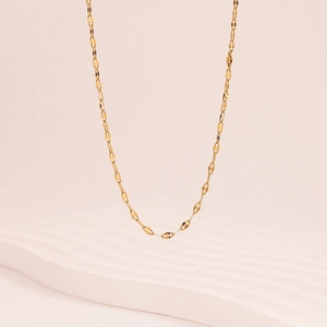 Close-up of golden oval link chain necklace with minimalist design and metallic texture