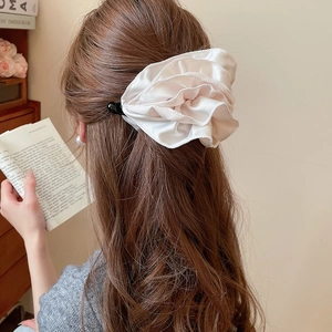 Grosse pince à cheveux fleur à pois plissée champagne portée sur cheveux bruns