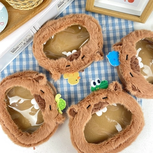 Detail of four Capybara plush coin purses with transparent PVC windows and zipper closure