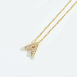 Detail of gold letter A pendant with pave-set white zircons on a classic chain necklace