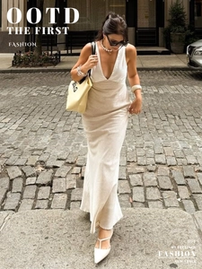 Abito lungo avorio con scollo a V profondo, collana di perle e borsa estiva chic
