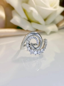 Macro shot of silver spiral ring with inlaid cubic zirconia and polished metal finish