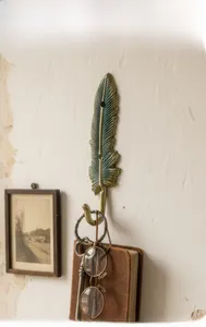 Dettaglio gancio a muro a forma di piuma in bronzo vintage con finitura in metallo