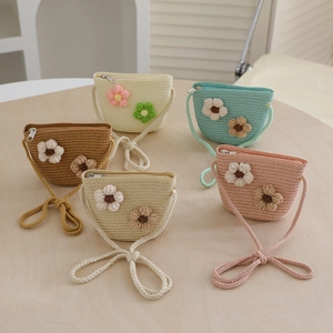 Detailed macro view of five colorful hand-woven straw crossbody bags with floral accents