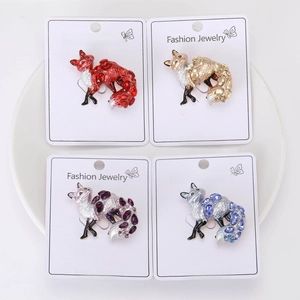 Detail view of four fox brooches in red, blue, purple, and champagne crystal finish