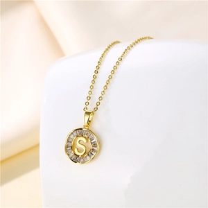Detailed view of an 18K gold stainless steel round pendant with letter S and cubic zirconia